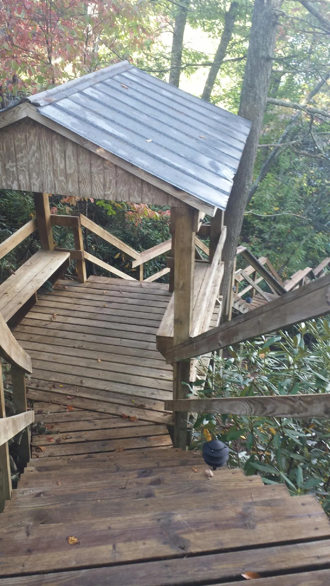 Metal roofed shelter over wooden steps on a wooded walkway — Skylight Repair & Installation work by our crew in Crowley