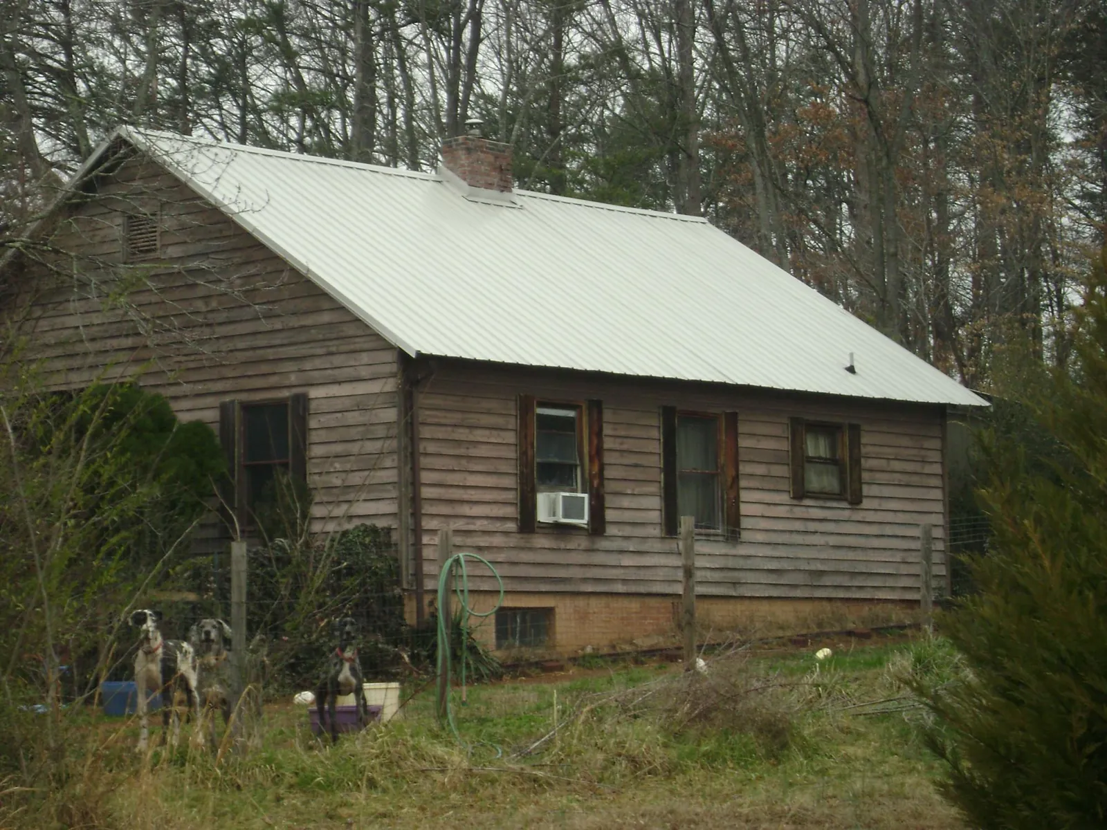 White metal roof on an old wood sided farmhouse, from a Metal Roof Installation job in Crowley